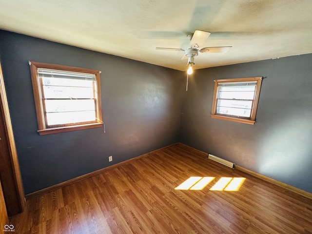 empty room with ceiling fan and hardwood / wood-style floors