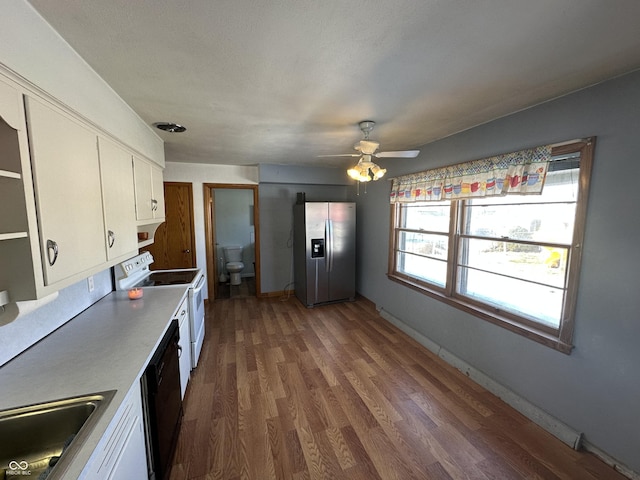 kitchen featuring dark wood-type flooring, white cabinets, stainless steel fridge, and white electric range