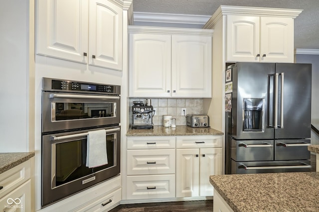 kitchen with crown molding, appliances with stainless steel finishes, tasteful backsplash, a textured ceiling, and white cabinets