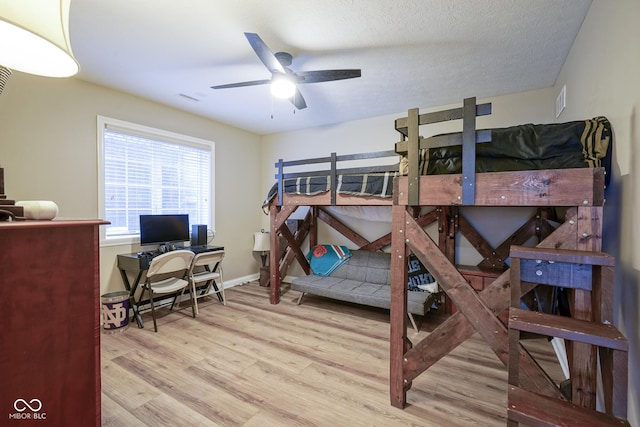 bedroom featuring ceiling fan, a textured ceiling, and wood-type flooring