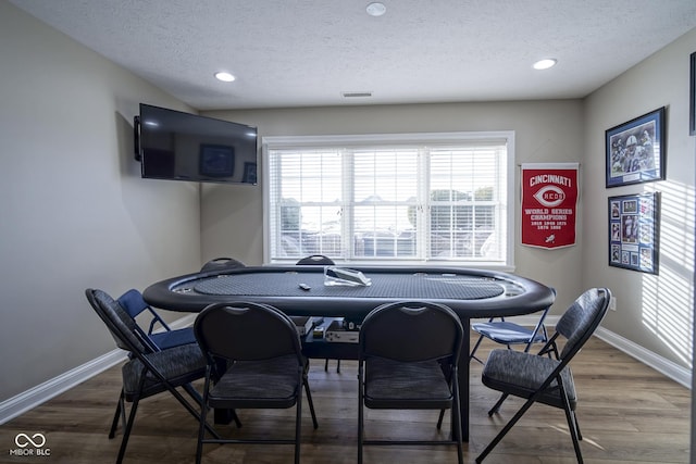 recreation room with hardwood / wood-style floors and a textured ceiling