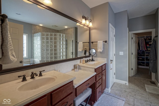 bathroom featuring tiled shower, tile patterned flooring, and vanity