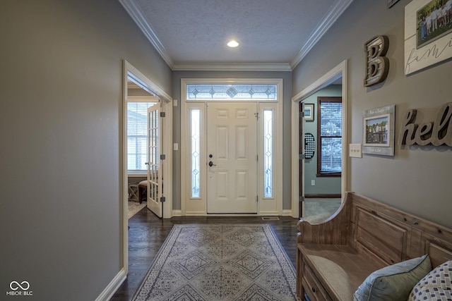 foyer entrance featuring dark wood-type flooring, a textured ceiling, and crown molding