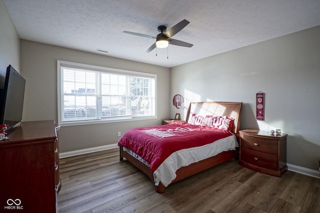 bedroom featuring hardwood / wood-style flooring, a textured ceiling, and ceiling fan