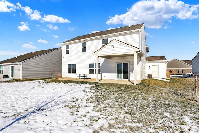 snow covered house featuring cooling unit and a patio area