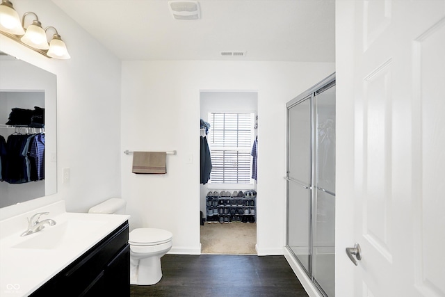 bathroom with vanity, toilet, walk in shower, and hardwood / wood-style floors