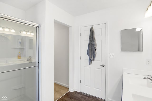 bathroom featuring wood-type flooring, sink, and an enclosed shower