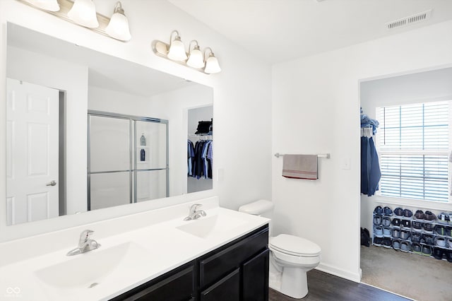 bathroom featuring vanity, toilet, hardwood / wood-style floors, and an enclosed shower