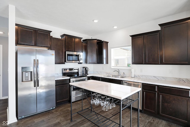 kitchen with sink, dark brown cabinets, dark hardwood / wood-style flooring, and appliances with stainless steel finishes