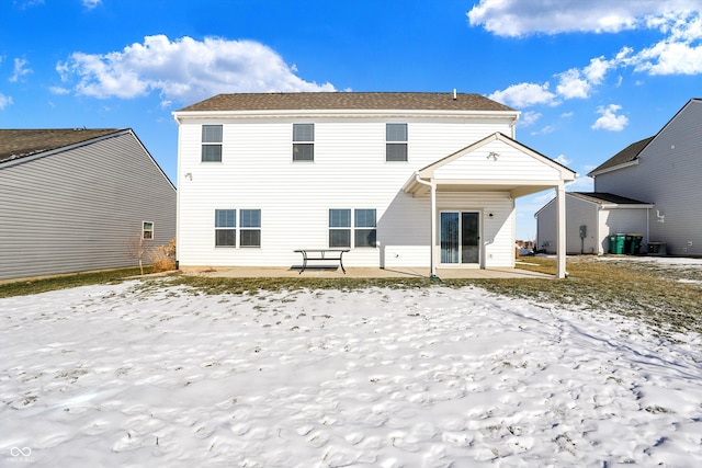 snow covered house featuring a patio