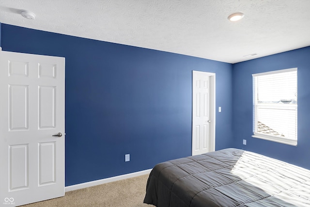 carpeted bedroom featuring a textured ceiling