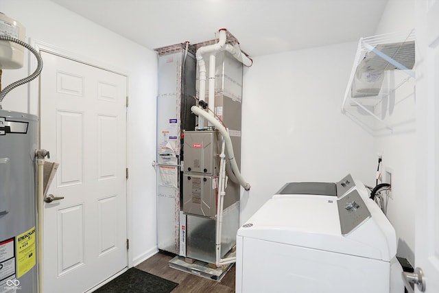 laundry room featuring water heater, dark wood-type flooring, and washer and dryer