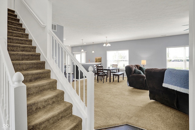 977 Capricorn Dr, Franklin, IN 46131 - living room featuring stairway, an inviting chandelier, carpet, and visible vents