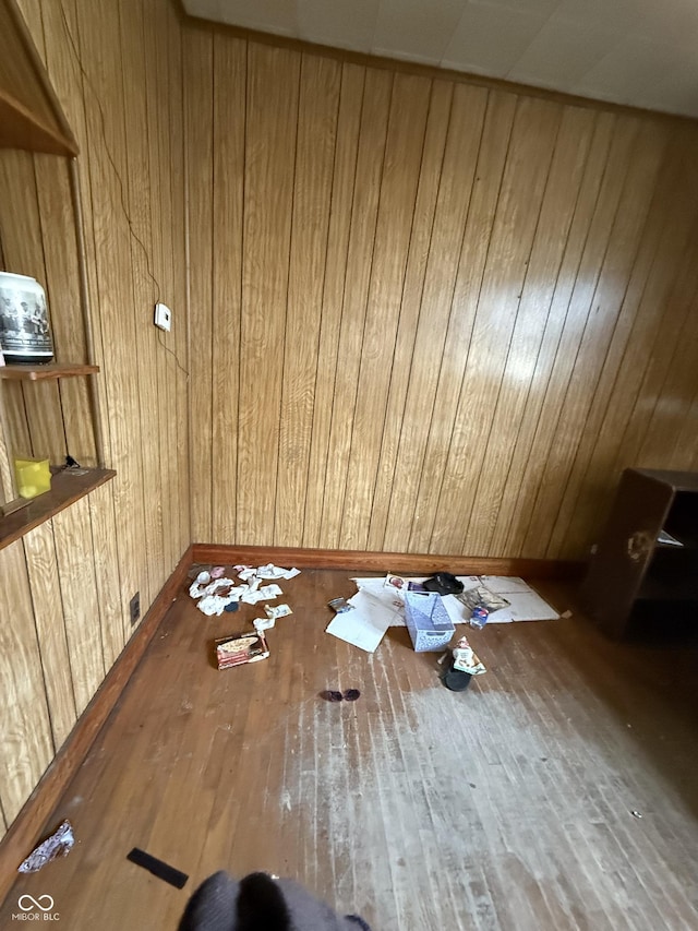 spare room featuring wood-type flooring and wood walls