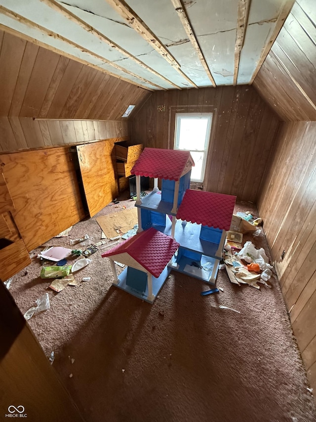 additional living space featuring wooden walls and vaulted ceiling