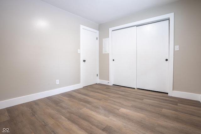 unfurnished bedroom featuring hardwood / wood-style floors and a closet