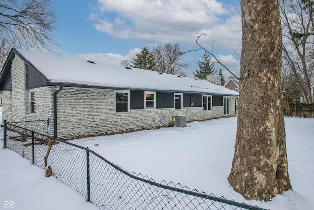 snow covered house with central AC