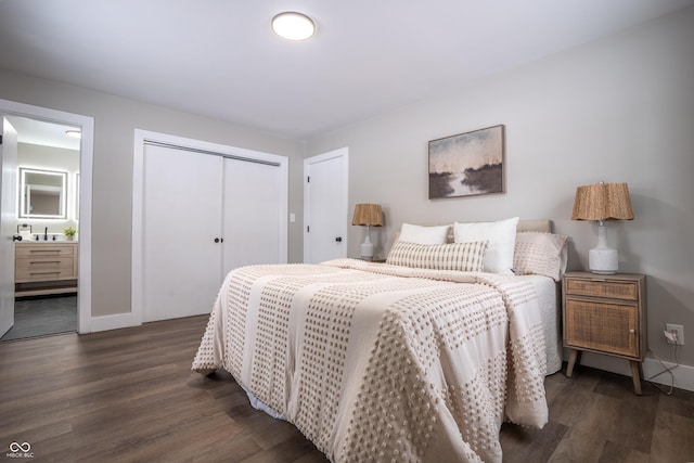 bedroom featuring dark wood-type flooring, sink, a closet, and ensuite bath