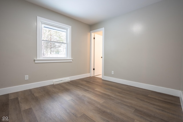 empty room with dark wood-type flooring