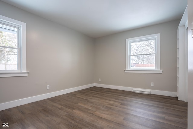 unfurnished room featuring dark hardwood / wood-style floors and a healthy amount of sunlight