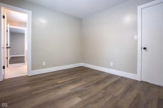 empty room with dark hardwood / wood-style flooring