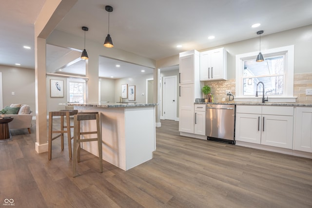 kitchen with decorative light fixtures, dark hardwood / wood-style floors, white cabinets, and dishwasher