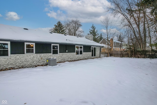 snow covered property with central air condition unit