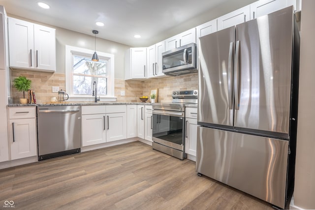 kitchen with white cabinets, pendant lighting, and appliances with stainless steel finishes