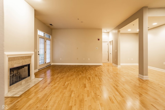 unfurnished living room with a fireplace and light hardwood / wood-style floors