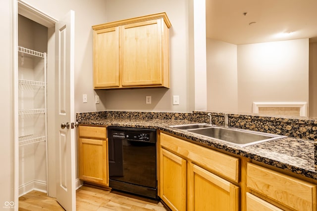 kitchen featuring dishwasher, sink, dark stone countertops, light brown cabinets, and light hardwood / wood-style flooring