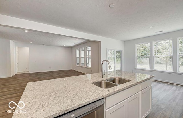 kitchen with sink, dark wood-type flooring, light stone countertops, a textured ceiling, and white cabinets