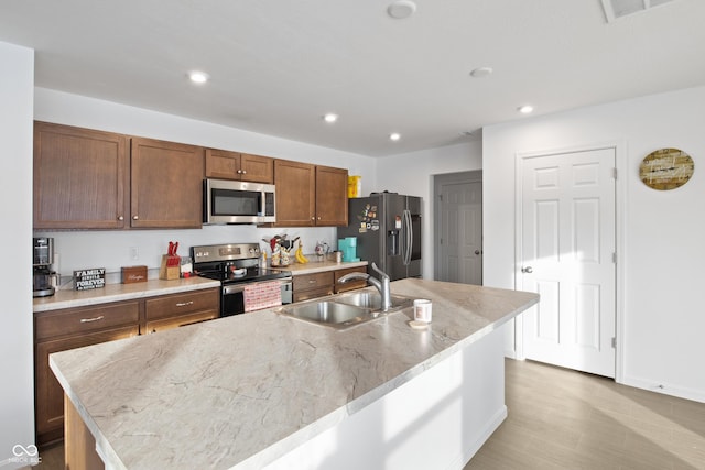 kitchen with a kitchen island with sink, appliances with stainless steel finishes, and sink