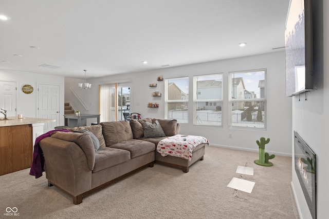 carpeted living room with sink and a chandelier