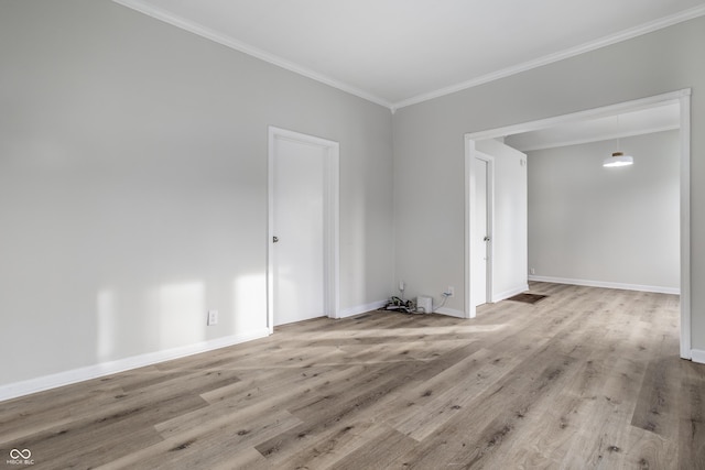 spare room with ornamental molding and light wood-type flooring