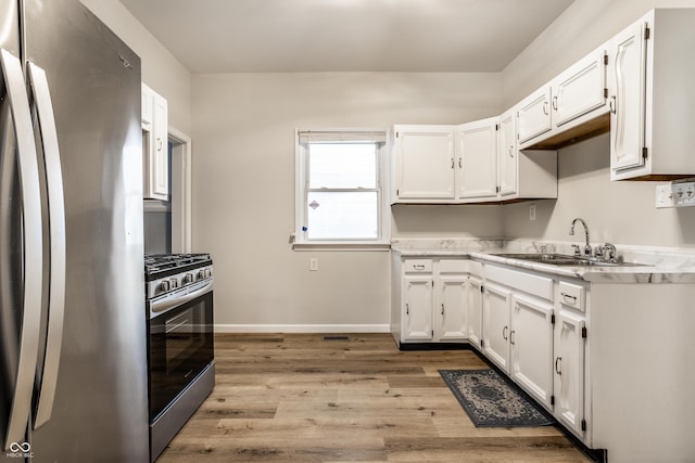 kitchen featuring white cabinetry, stainless steel appliances, light hardwood / wood-style floors, and sink