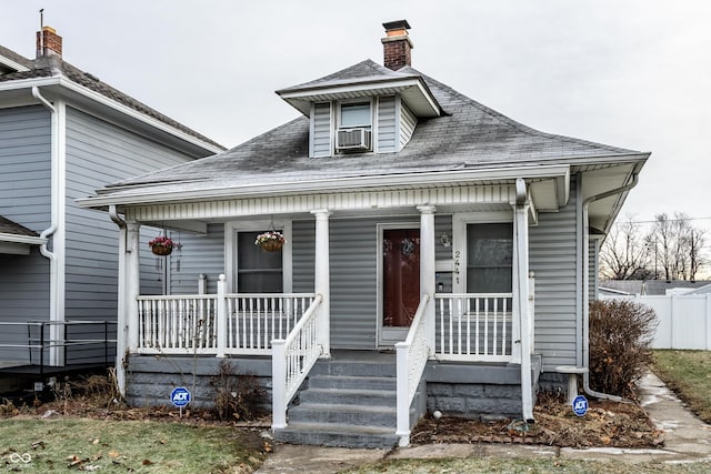 bungalow with a porch and cooling unit