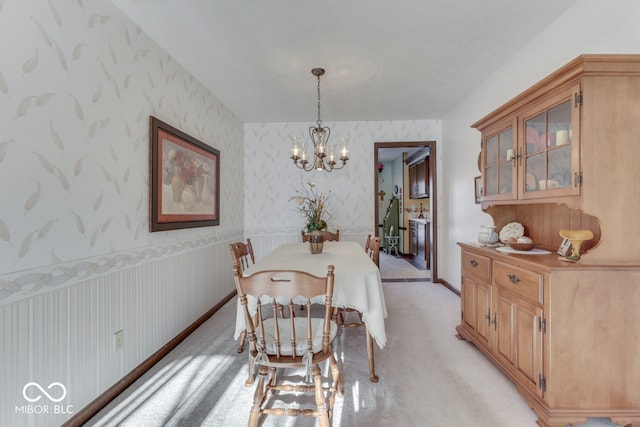 carpeted dining area featuring a chandelier