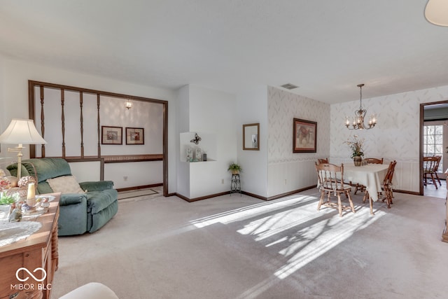 carpeted living room with a chandelier