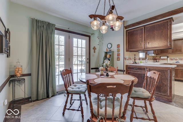 tiled dining room featuring a textured ceiling and a healthy amount of sunlight