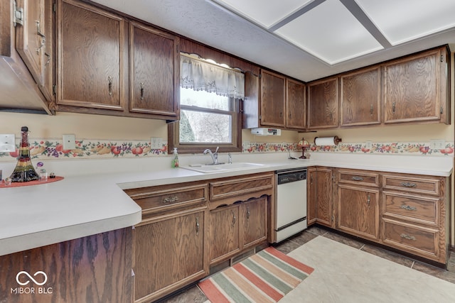 kitchen with sink, light tile patterned floors, dark brown cabinetry, and white dishwasher