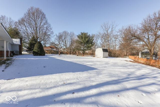 yard covered in snow featuring a storage unit