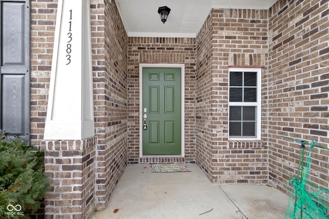 doorway to property with brick siding