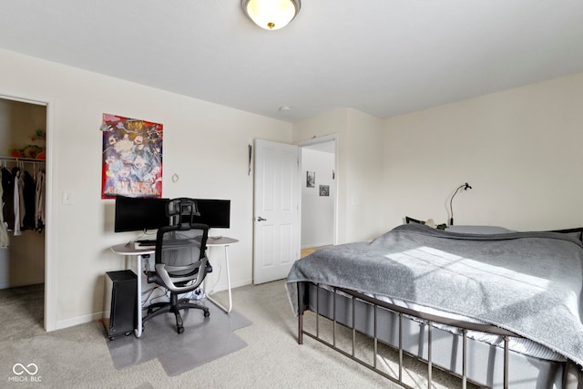 bedroom with a spacious closet, baseboards, a closet, and light colored carpet