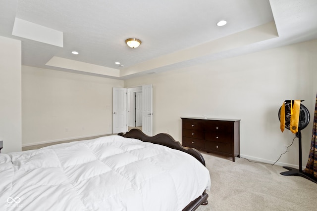 bedroom featuring recessed lighting, baseboards, a raised ceiling, and light colored carpet