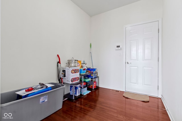 recreation room featuring baseboards and wood finished floors