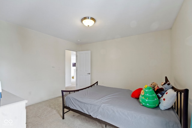 bedroom featuring light carpet and baseboards