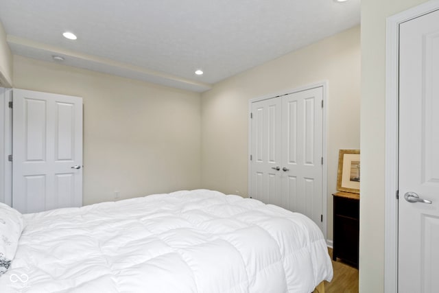 bedroom with a closet, light wood-style flooring, and recessed lighting