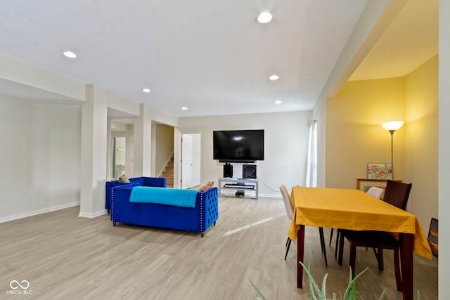 living room featuring light wood-type flooring, recessed lighting, baseboards, and stairs