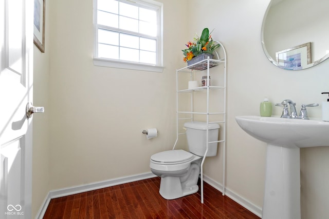 bathroom with a sink, wood finished floors, toilet, and baseboards