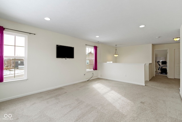 spare room with light carpet, recessed lighting, and baseboards